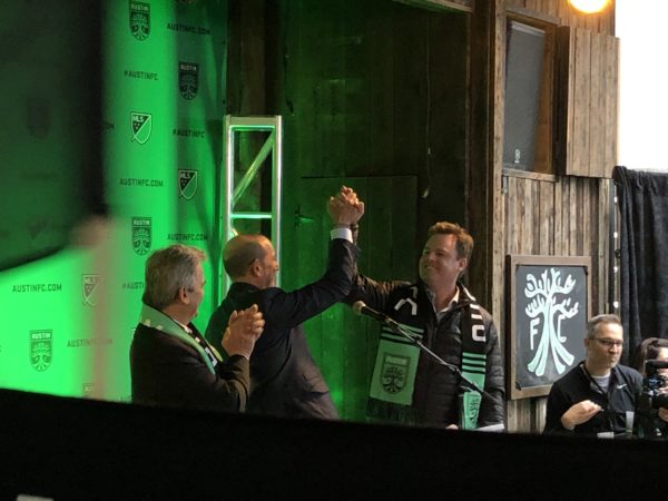 Don Garber and Anthony Precourt high five